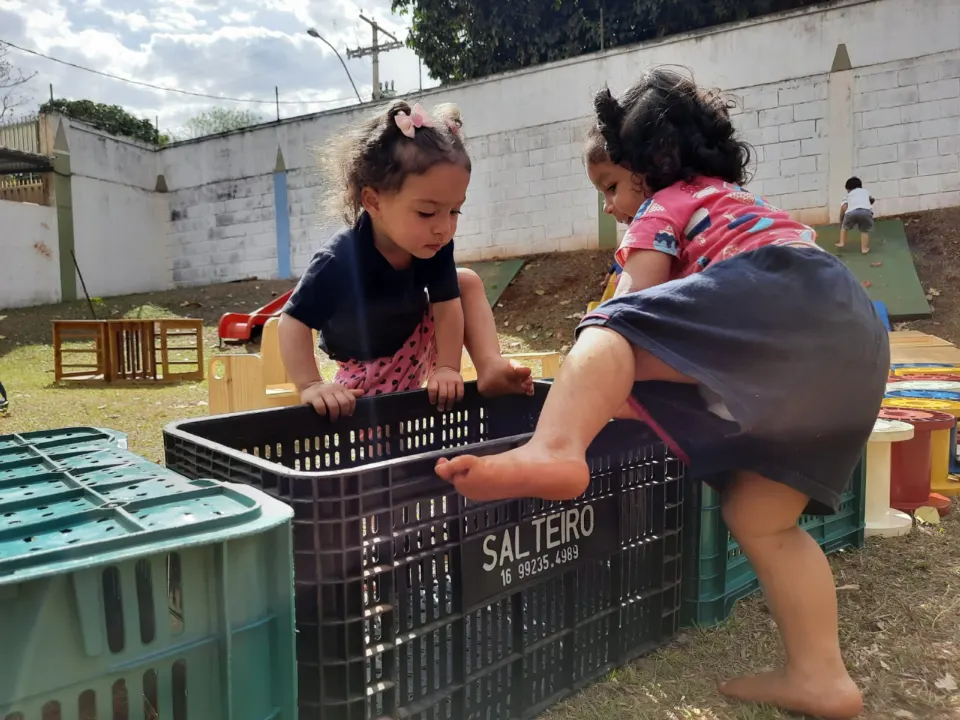 Crianças escalando caixas no pátio externo
